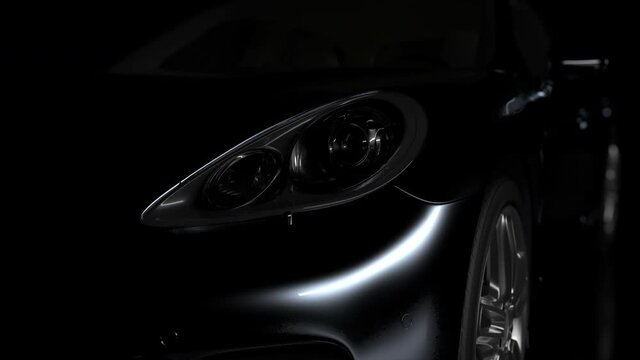 the black car gradually emerges from the darkness due to the illumination and disappears again in the darkness. close-up on headlights