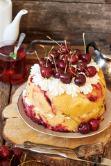 Cherry cake. Yeast bun with cherries and cream. Top view, wooden background.