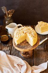 Cake on a wooden cake stand. Shortcrust pastry cake, decorated with shortcrust crumbs. Wooden background, rustic, side view. 