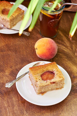 Vegetarian peach pie. The cake contains banana, coconut oil, sugar, flour and peaches. Wooden background.
