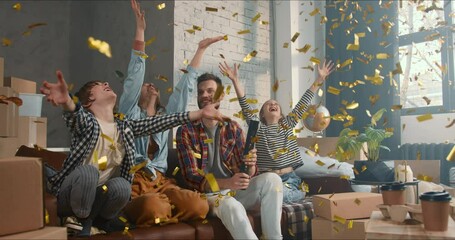 Celebrating new home. Happy young family with two children sit on couch shooting confetti cannon buying fancy apartment.