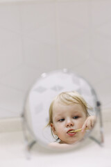 Fototapeta premium little funny girl brushing her teeth in the bathroom