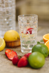 Summer drink. Citrus lemonade with mint, ice and strawberry. Sliced citrus on table
