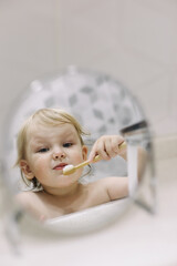 little funny girl brushing her teeth in the bathroom