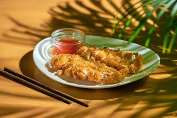 Breaded chicken steak with spicy Sichuan sauce. Chicken schnitzel