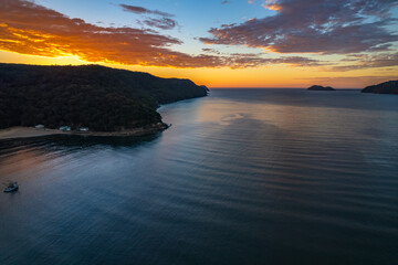 Fototapeta na wymiar Peaceful sunrise over the bay with boats and mountain