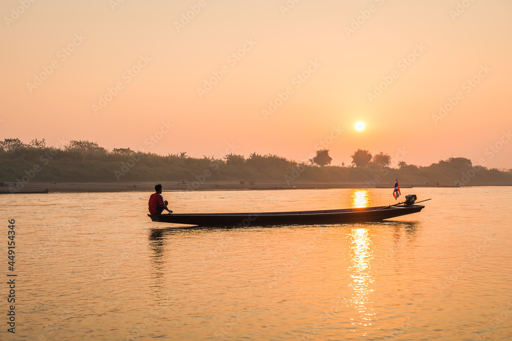 Wall mural Fishermen in the boat on sunrise background