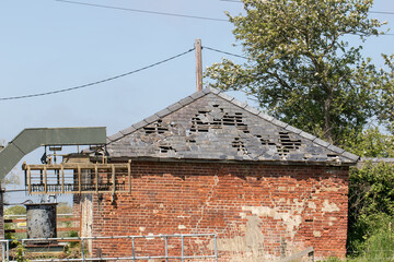 Damaged roof. Slate tiles falling off derelict agricultural building