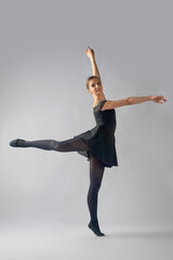 Young woman ballerina doing fouette on background