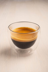 Coffee in glass cup on white wooden background