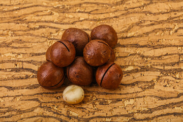 Brown macadamia nut heap over background