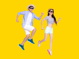Fototapeta na wymiar Happy young couple in sunglasses and hats. Isolated on yellow background.