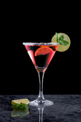 Pink margarita cocktail in a cocktail glass and a slice of lime