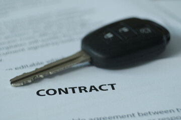 A contract with a car key on the table.