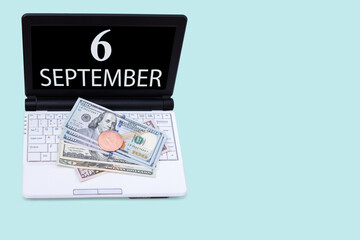 Laptop with the date of 6 september and cryptocurrency Bitcoin, dollars on a blue background. Buy or sell cryptocurrency. Stock market concept.