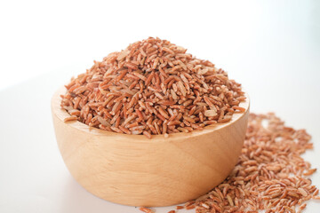 Germinated Sangyod brown GI Muang Phatthalung rice in the wooden bowl on white background. Healthy food.This rice nose have lot of various kinds of nutrients.