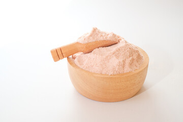 Himalayan pink salt powder in wooden bowl and scoop isolated on white background. 