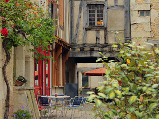 Fototapeta na wymiar Empty restaurant in a narrow street of a French town of Noyers sur Serein in Burgundy, one of the most beautiful villages of France with historic architecture during Covid-19 coronavirus pandemic