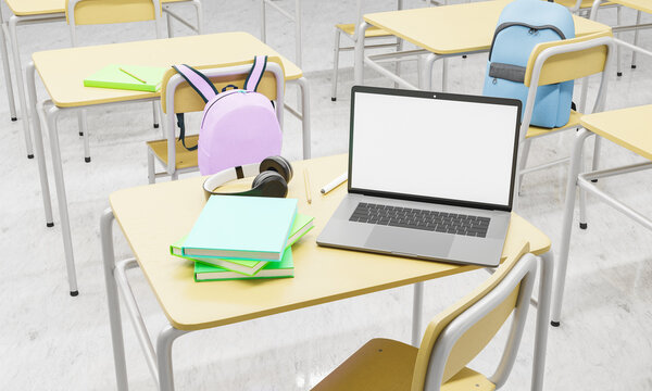 laptop on a school desk in a classroom with books and supplies around