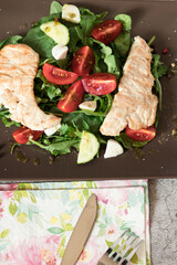 Salad with spinach leaves, arugula, cherry tomatoes, mozzarella and pieces of meat. Diet food. Homemade.