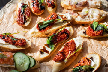 Tasty sandwiches at buffet table - bruschetta with roasted cheese and sun dried tomatoes