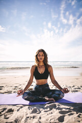 Fototapeta na wymiar Fitness woman doing meditation on the beach