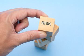 Risk Management Concept, Businessman placing wood block to stack of woods structure