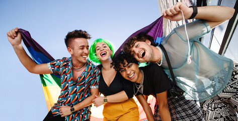 Group of LGBTQ+ people celebrating with pride flag - obrazy, fototapety, plakaty