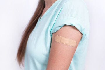Teenage girl in mask with Band-Aid on shoulder after vaccination against coronavirus or flu. Mandatory prevention for young people for immunity from virus. person isolated on white background.
