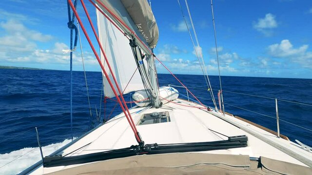 White sailing vehicle is rocking on the sea waves. Sailing boat, yacht sailing on opened sea.