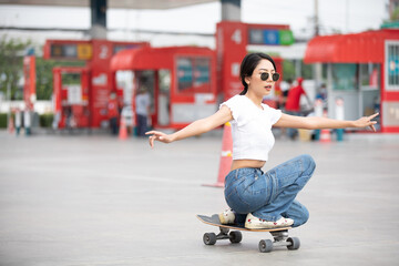 Beautiful young skater woman riding on skateboard