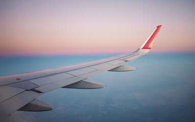 wing of an airplane in the sky during sunset. travel concept. flight by plane.