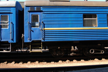A blue sleeping train wagon at a railway station waiting for passengers. Side view. Railroad travel concept.