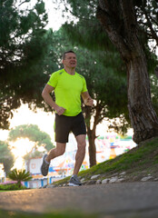 At sunset a sporty man in sneakers starts his morning run