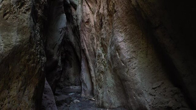 Camera move at the narrow canyon of a mountain cave, illuminated by the sun.Beautiful rocky cave