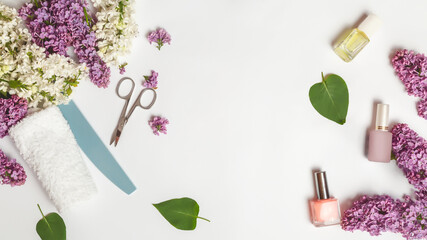 Obraz na płótnie Canvas Flat lay composition with personal care products with branches of lilac on white table.background. Nails care. Manicure, pedicure beauty salon concept. copy space