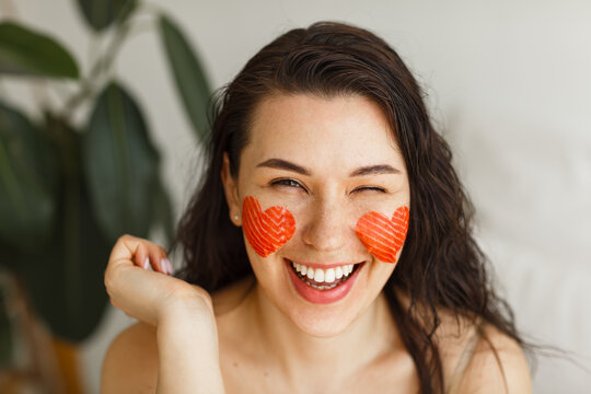 Young attractive girl  applying salmon patches in the green leaf background