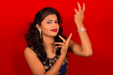 Naklejka premium Closeup of Indian young girl in blue dress with red background