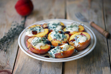 Baked peaches with gorgonzola cheese and thyme. Healthy snack.