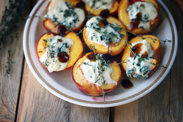 Baked peaches with gorgonzola cheese and thyme. Healthy snack.