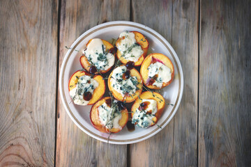 Baked peaches with gorgonzola cheese and thyme. Healthy snack.