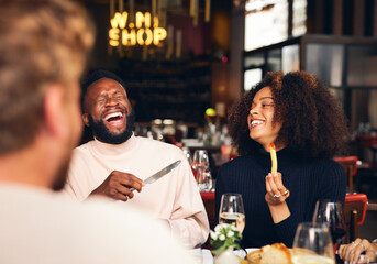 Couple eating meal and laughing in restaurant