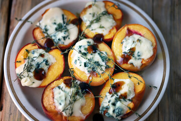 Baked peaches with gorgonzola cheese and thyme. Healthy snack.