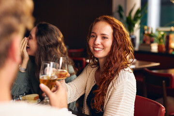 Woman toasting wine at dinner