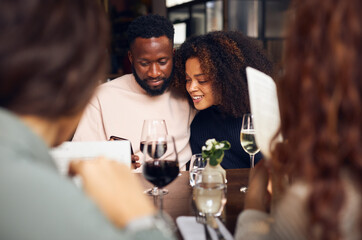 Young couple looking at phone in wine bar