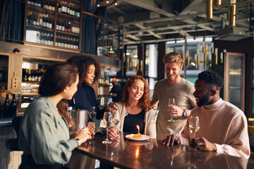 Friends celebrating birthday in wine bar