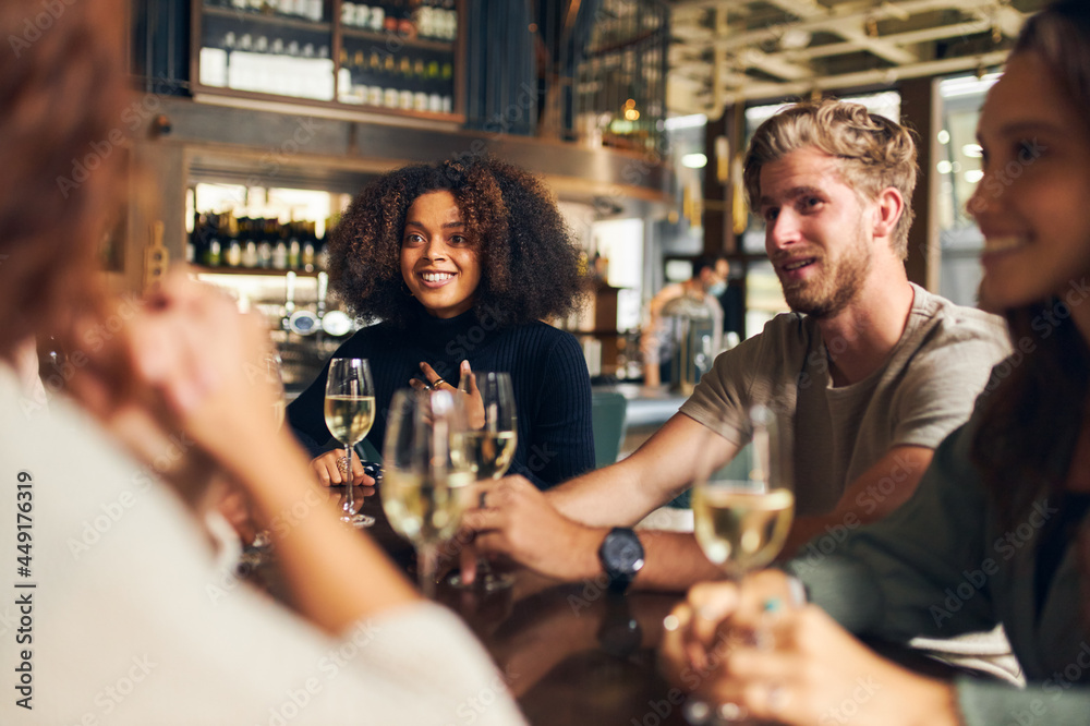 Wall mural friends relaxing with wine in bar