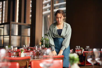 Female restaurant owner setting tables