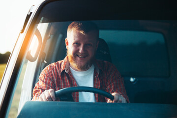 Smiling bearded driver driving his car