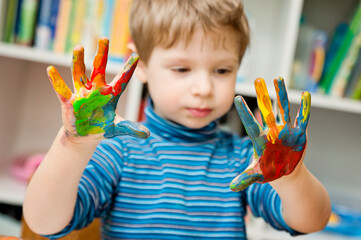 little pre-school artist. Boy painting with hands. Art education, Montessori program, sensory and...